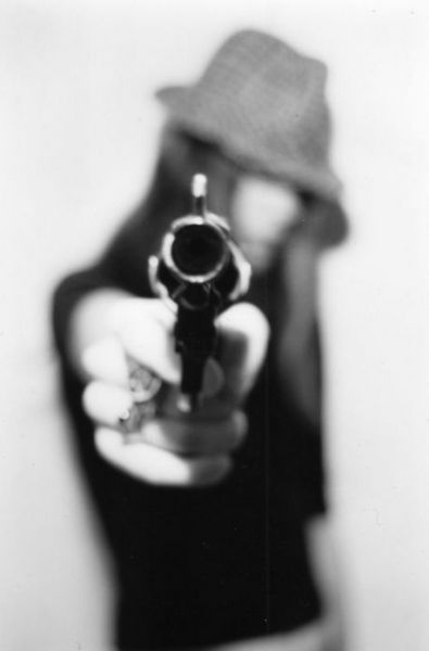 Девушка в шляпе с пистолетом в руке