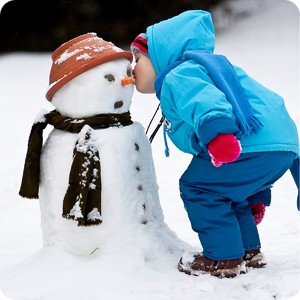 Мальчик на улице целует снеговика