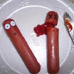 Две смешные сосиски на тарелке с кетчупом